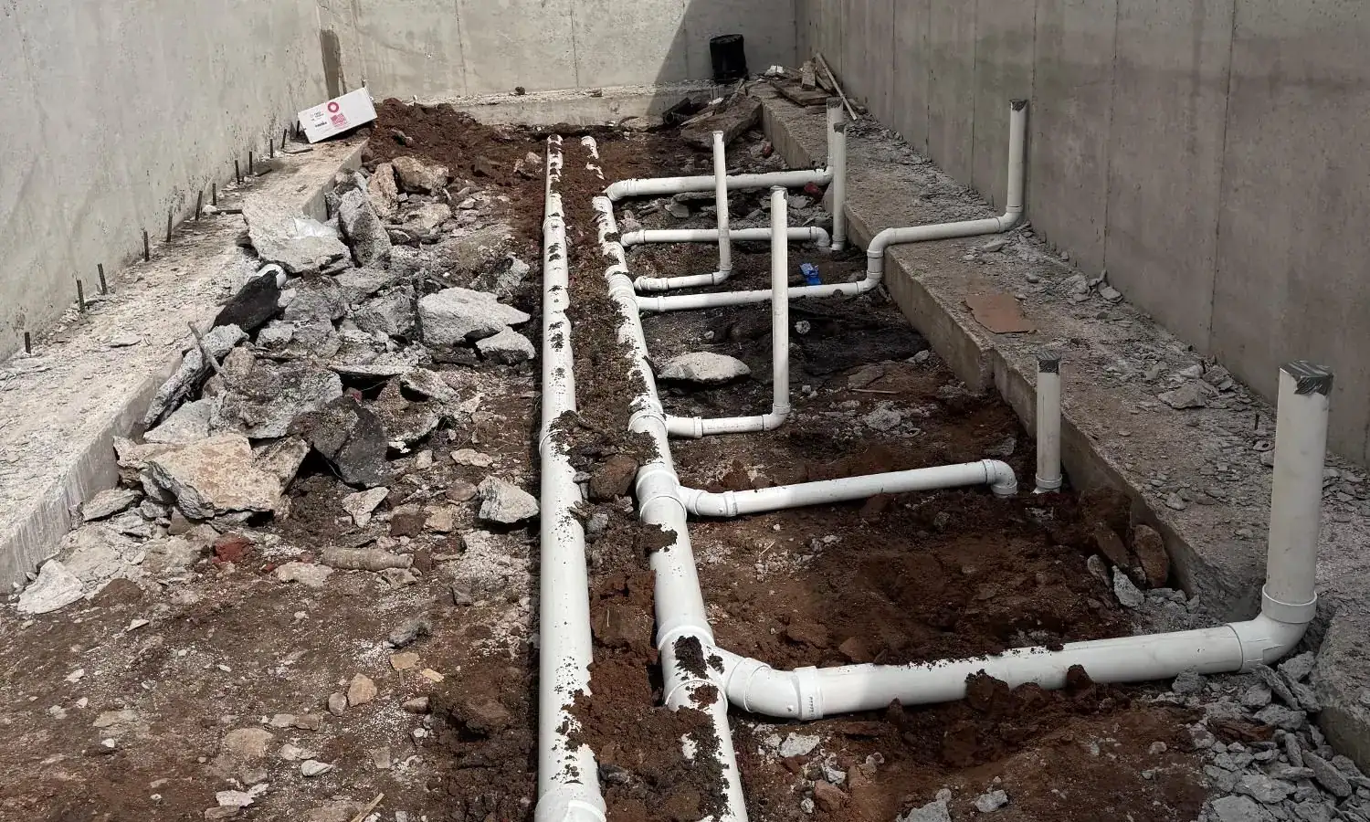 New PVC drain lines laid in an open foundation on an AlbPlumbing job in Philadelphia