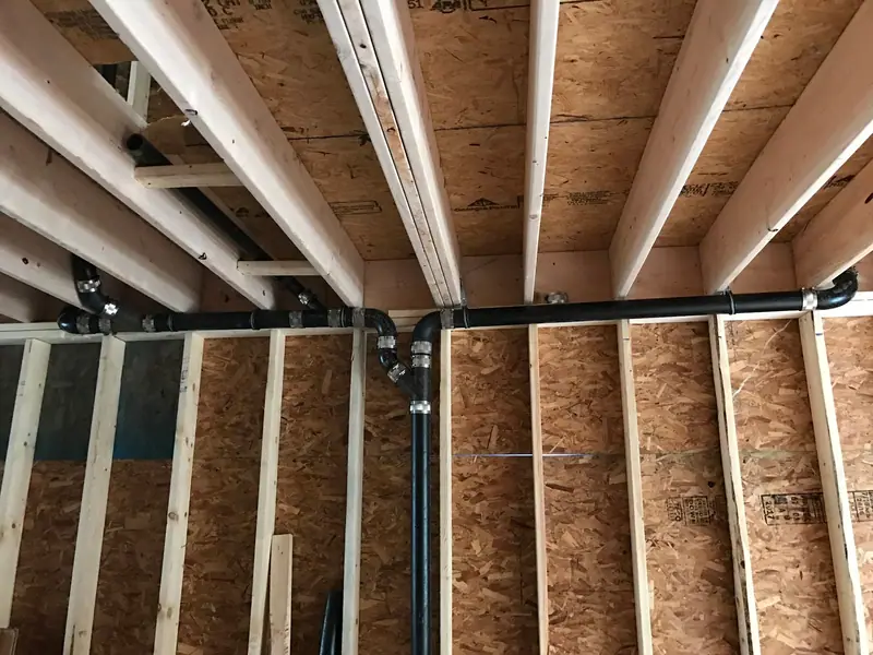 New drain and vent lines through floor framing on an AlbPlumbing new build
