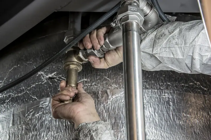 Plumber fitting a steel pipe in a commercial utility space